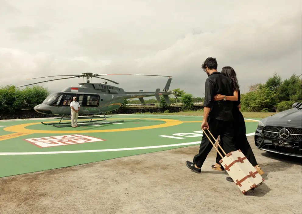Guests arriving by private car and boarding a Balicopter helicopter at the helipad